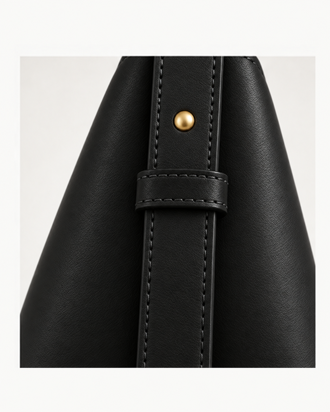Detalle lateral con trabilla y herraje del bolso de piel SENDA 36 de CHAGOM en color negro#Color_Negro